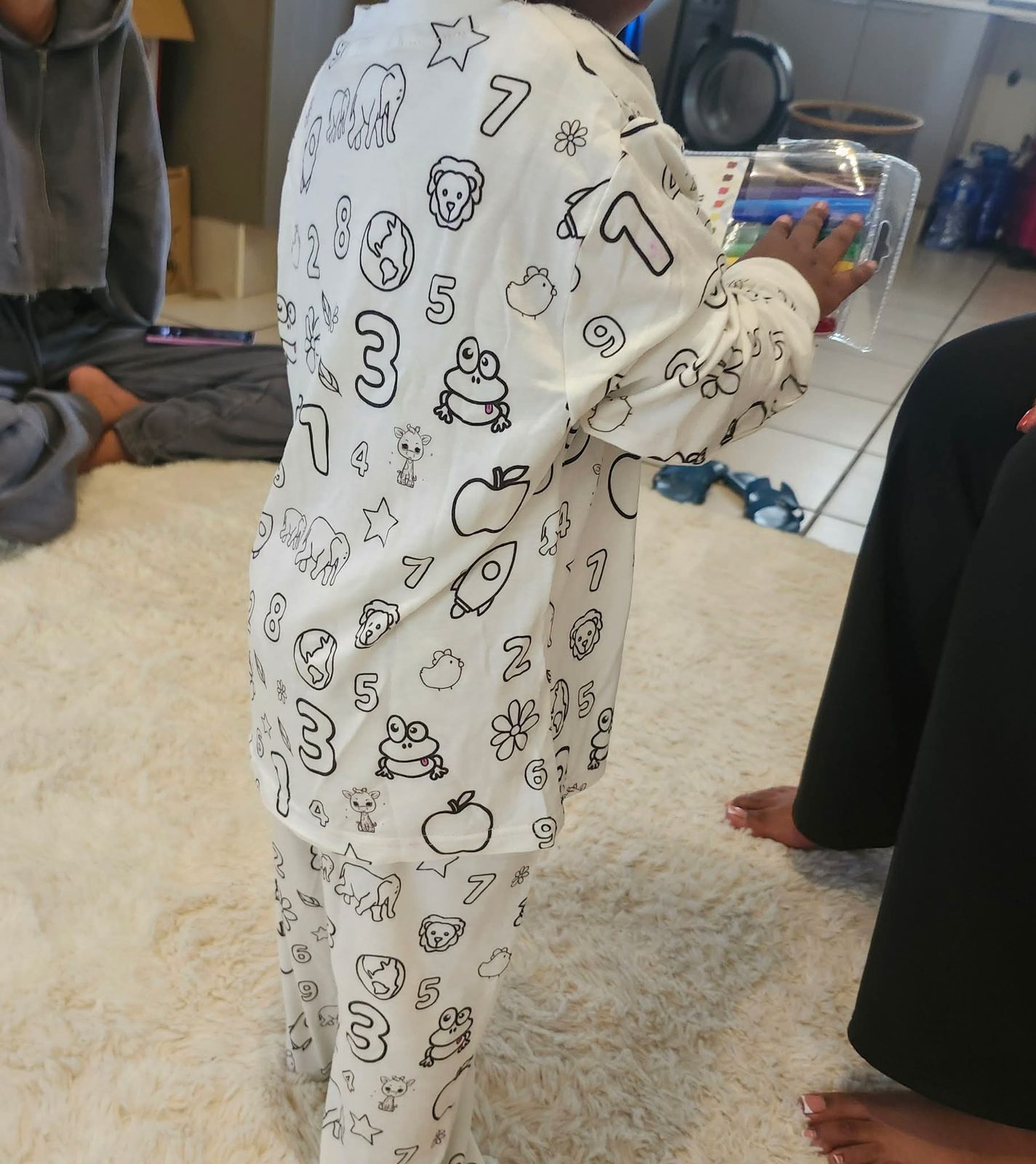 A child colouring in their DreamDoodle pyjamas with a set of pens