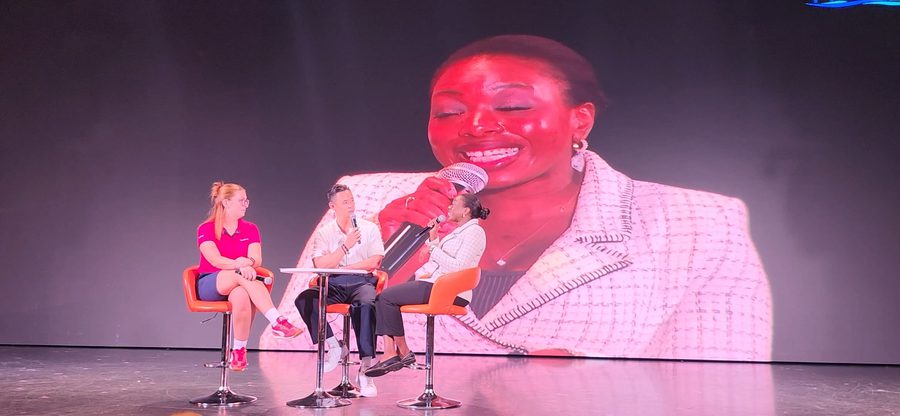 Hayley Molefe speaking on a panel with a microphone
